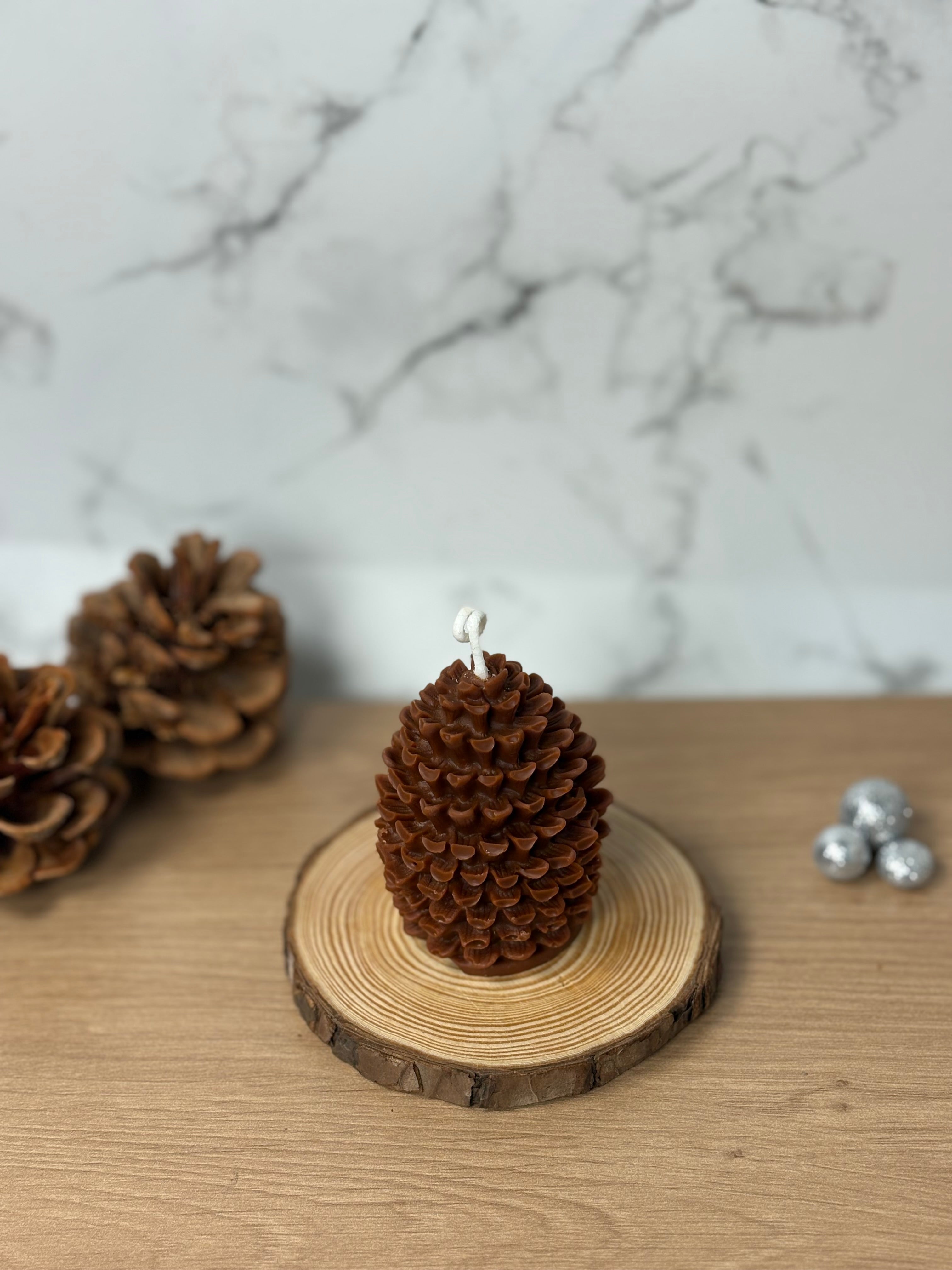 Handgemachte unbeduftete Tannenzapfen-Kerze aus 100% Bio-Sojawachs. Elegante, natürliche Deko in Form eines Tannenzapfens auf einem Holzuntergrund.