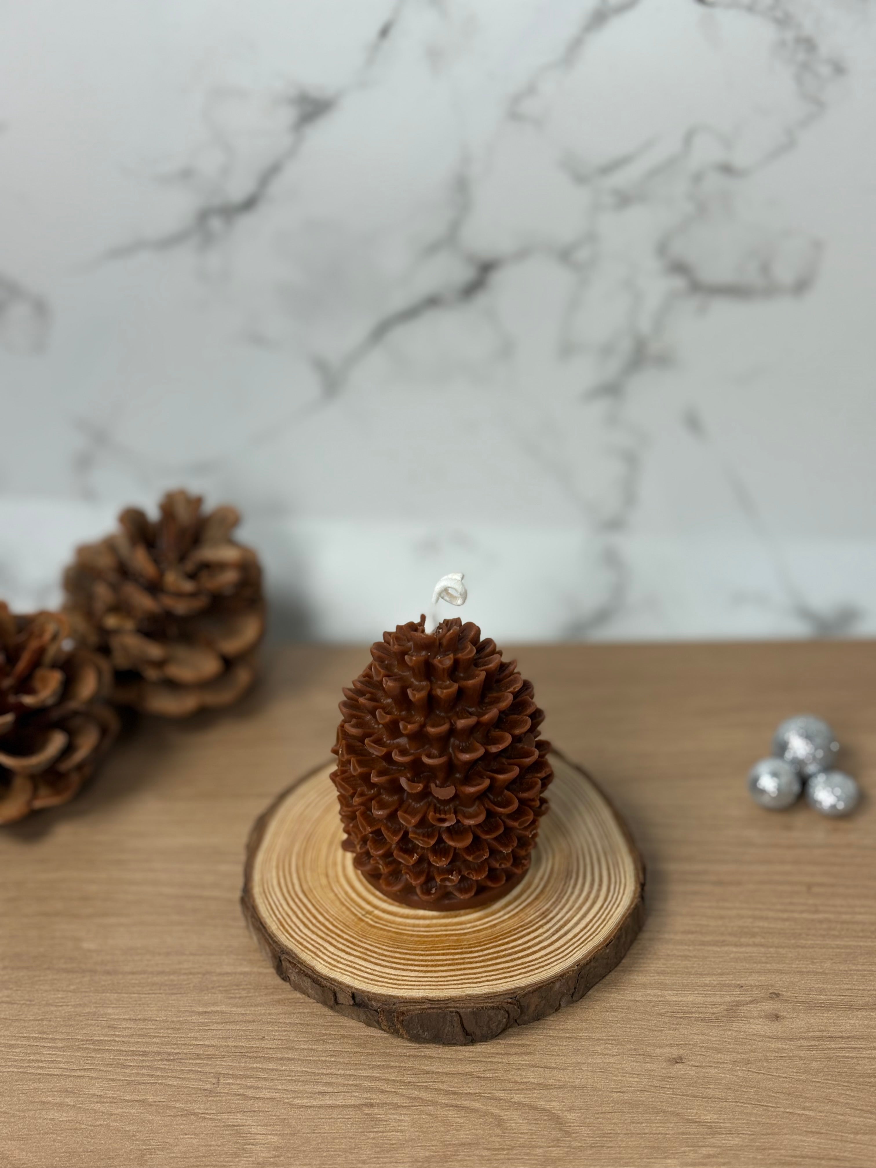 Handgemachte unbeduftete Tannenzapfen-Kerze aus 100% Bio-Sojawachs. Elegante, natürliche Deko in Form eines Tannenzapfens auf einem Holzuntergrund.